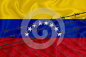 Developing Venezuela Flag, mesh fence and barbed wire. Concept of isolation of emigrants. With place for your text