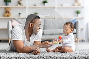 Development Activities With Babies. Black Father Playing With Infant Child At Home