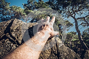 Development Attainment Motivation Career Growth Concept. Man`s hand clings to a rock. Concept of motivation, success, willpower photo