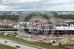 Development of commercial housing in USA. Construction works on monolithic frame. Large building site with scattered photo