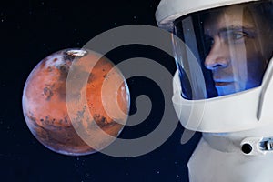Development of Mars, concept. Astronaut, looking at the planet Mars. Elements of this image furnished by NASA.