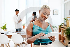 The device favoured by go getters everywhere. a young businesswoman using a digital tablet in a modern office.