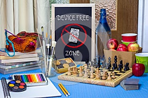 Device Free Zone chalk board on table with games, art materials, books and chess board