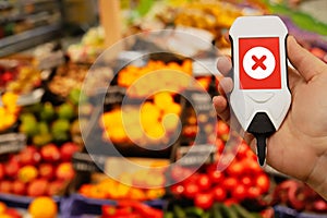 device in hand measuring nitrates and pesticides on market vegetables and fruits photo