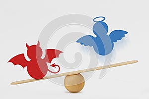 Devil and angel on balance scale - Predominance of evil over good concept