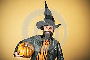 Devil man. Thanksgiving seasonal cooking ingredients. Portrait of Handsome man with pumpkin over  background