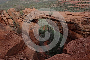 Devil\'s Bridge, a natural sandstone arch, surrounded by evergreens on Devil\'s Bridge Trail in Sedona, Arizona