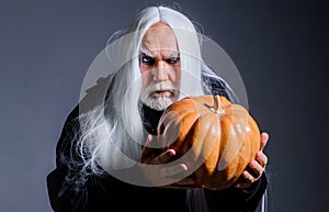 Devil vampire man with Halloween pumpkin. Horror. Male demon with Jack-o-lantern. Magician witcher old man. Devil man