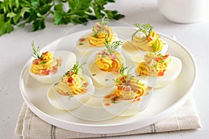 Deviled stuffed eggs with egg yolk, bacon, mustard and dill