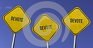 devote - three yellow signs with blue sky background photo