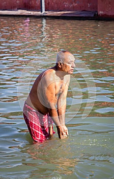 devotee praying after bathing in holy river water at morning from flat angle photo