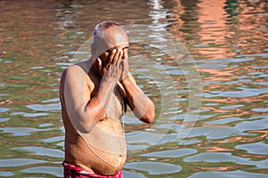 devotee praying after bathing in holy river water at morning from flat angle photo