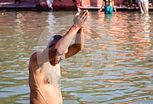 devotee praying after bathing in holy river water at morning from flat angle photo