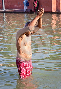 devotee praying after bathing in holy river water at morning from flat angle photo