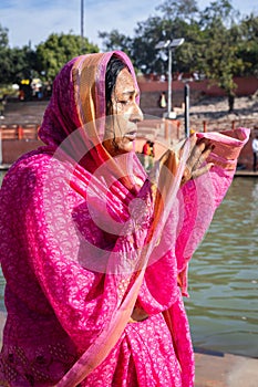 devotee praying for holy god after bathing in holy river water at morning from flat angle photo