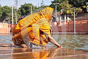 devotee praying for holy god after bathing in holy river water at morning from flat angle photo