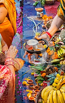 devotee praying with religious offerings for sun god in Chhath festival