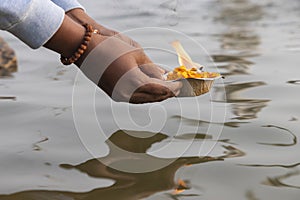 A devotee releasing the worship lamp/diya in the river Ganga