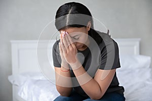 Devout African woman prays in morning sitting on bed