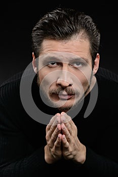 Devout man praying. Devout bearded man praying and holding his h