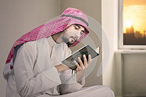 Devout muslim man reads Quran at home