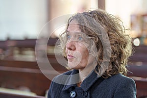 Devout religious woman praying in a church