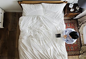 Devout woman with a bible book praying by the bed