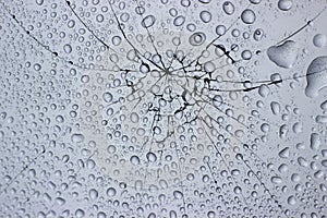 Dew drops on cracked broken window glass