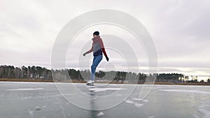 Dexterous young woman is skating on ice in nature. White skates are great for winter fun