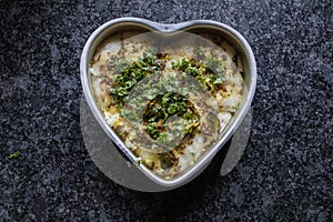 Dhokla in a heart shaped bowl with gray granite background