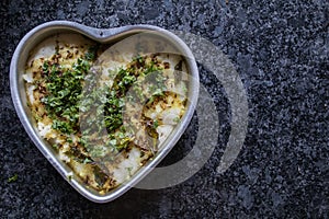 Dhokla in a heart shaped bowl with gray granite background