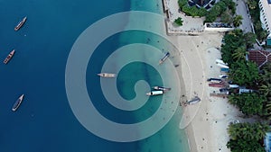 Dhow boats and Stone Town city at Unguja Zanzibar island in Tanzania. Indian ocean aerial view.