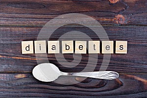 Diabetes block wooden letters and sugar pile on a spoon