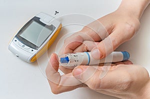 Diabetes concept. Hands holds needle for measuring glucose level.