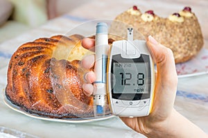 Diabetes, diet and unhealthy eating concept. Hand holds glucometer.