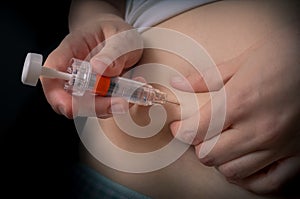 Diabetes and glycemia concept. Patient is injecting insulin injection to belly. photo