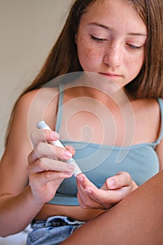 Diabetes and glycemia, a teenage girl examines her sugar level. Puncturing a child& x27;s finger with a lancet.