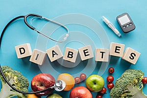 diabetes lettering made of wooden cubes with medical equipment and fruits