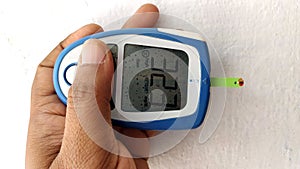 Diabetes machine in hand prick finger to make punctures to obtain small blood specimens for blood glucose, using glucose meter