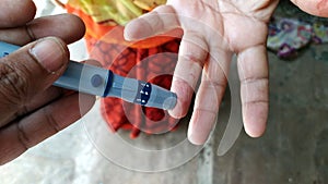 Diabetes machine in hand prick finger to make punctures to obtain small blood specimens for blood glucose, using glucose meter