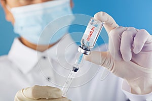 Diabetes treatment a bottle of insulin and a syringe with a needle in the hands of a doctor