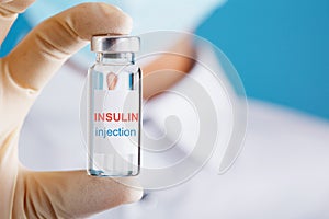 Diabetes treatment a bottle of insulin and a syringe with a needle in the hands of a doctor
