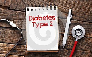 DIABETES TYPE 2 words in the notebook next to the stethoscope