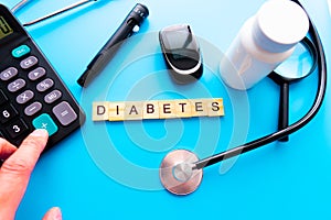 Diabetes Wooden Text. Medicine, Diabetes, Glycemia, Health care and people concept - close up of lancelet, Glucose meter and