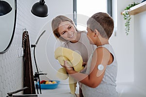 The diabetic boy getting ready in the morning, while wearing a continuous glucose monitoring sensor on his arm.