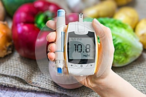 Diabetic diet and diabetes concept. Hand holds glucometer. photo