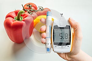 Diabetic diet, diabetes and healthy eating concept. Glucometer and vegetables. photo