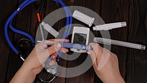 A diabetic woman dials the right dose of insulin on an insulin pen.