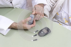 Diabetologist punctures the finger of a woman suffering from diabetes.