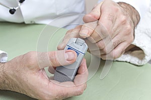 Diabetologist punctures the finger of a woman suffering from diabetes.